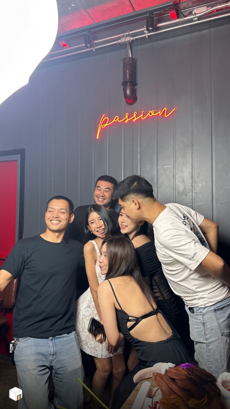โฟโต้บูธ กลุ่มเพื่อนยิ้มและโน้มตัวเข้าหากล้องขณะถ่ายโฟโต้บูธ